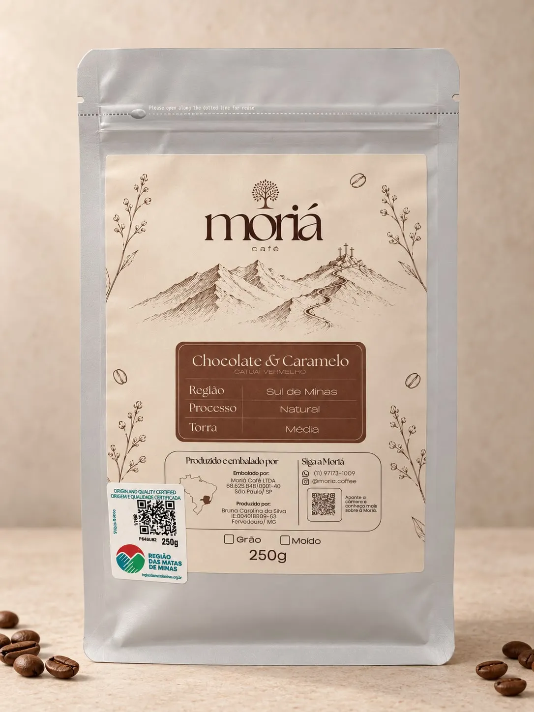 Embalagem do Moriá Especial, pacote de 250g, com grãos de café torrados sobre a mesa.